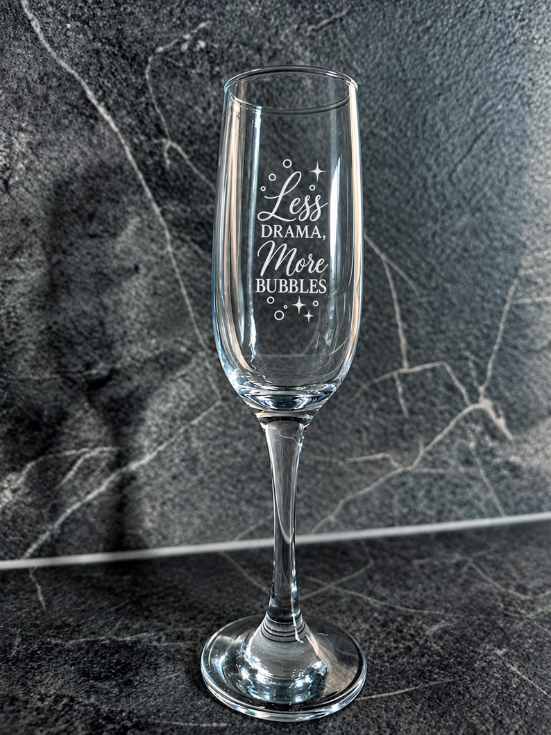 Close-up of Less Drama More Bubbles champagne flute engraving