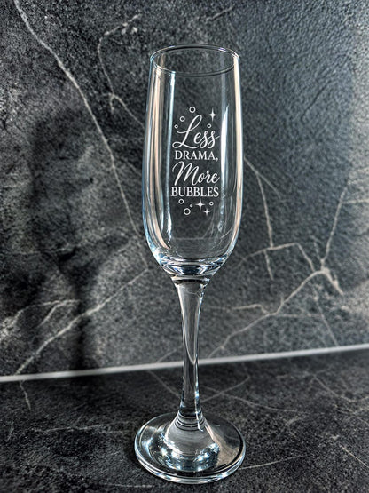 Close-up of Less Drama More Bubbles champagne flute engraving